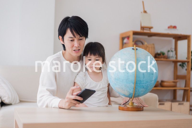 パパと地球儀を使って勉強する家族