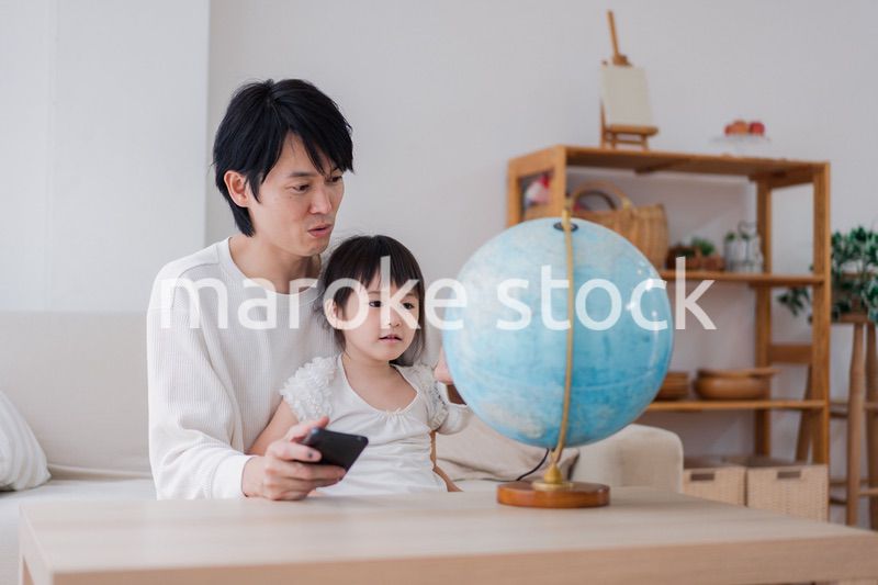 パパと地球儀を使って勉強する家族