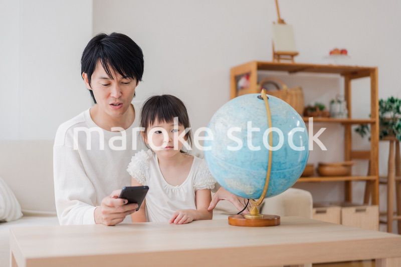 パパと地球儀を使って勉強する家族