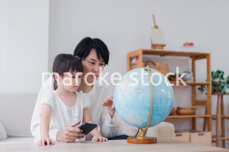 パパと地球儀を使って勉強する家族