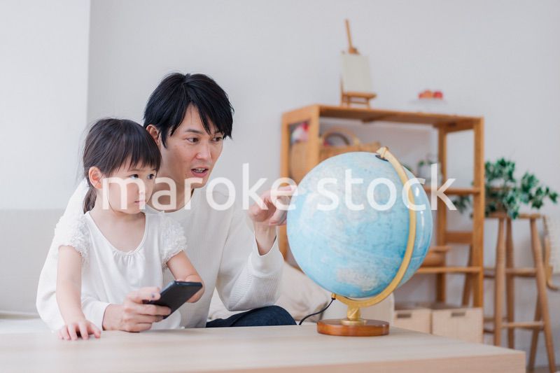 パパと地球儀を使って勉強する家族