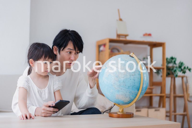 パパと地球儀を使って勉強する家族