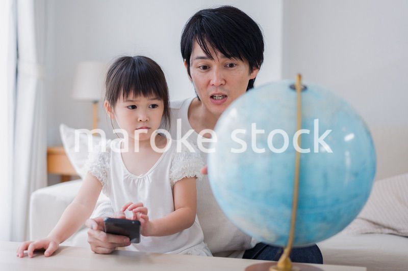 パパと地球儀を使って勉強する家族