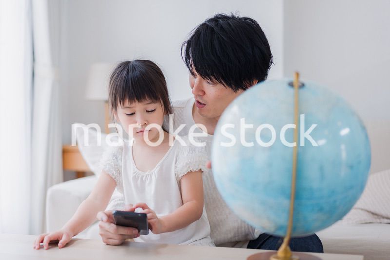 パパと地球儀を使って勉強する家族