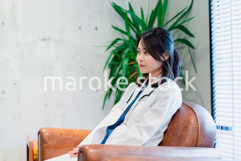 白衣で休憩をする女性の医師