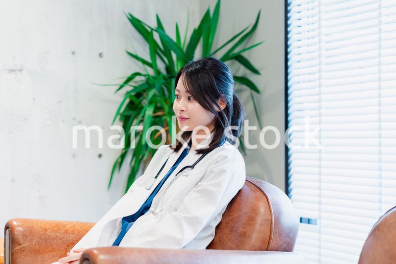 白衣で休憩をする女性の医師