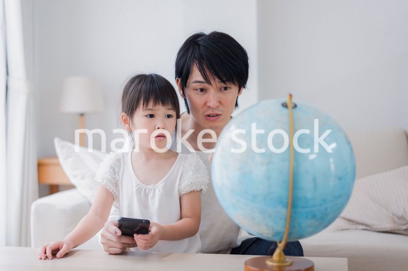 パパと地球儀を使って勉強する家族