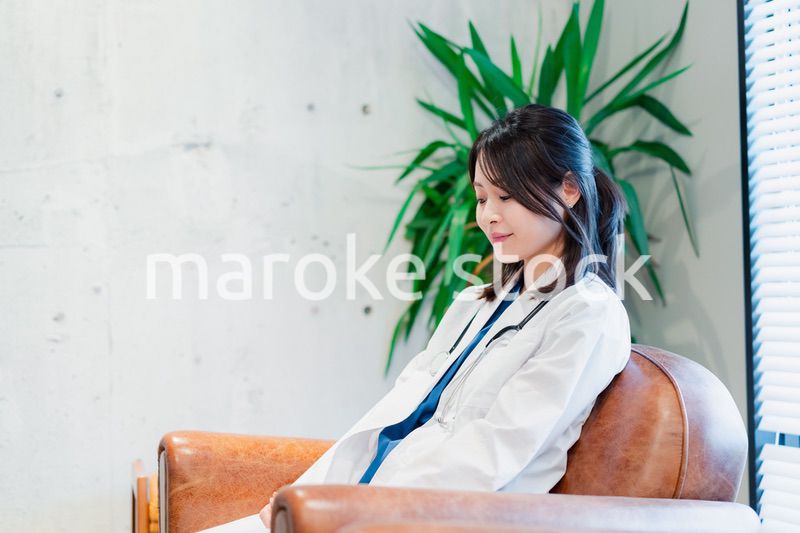 白衣で休憩をする女性の医師