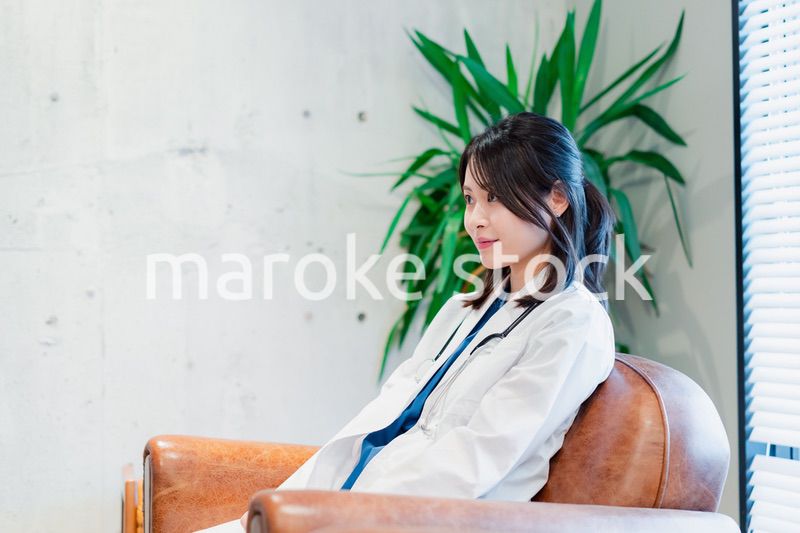 白衣で休憩をする女性の医師