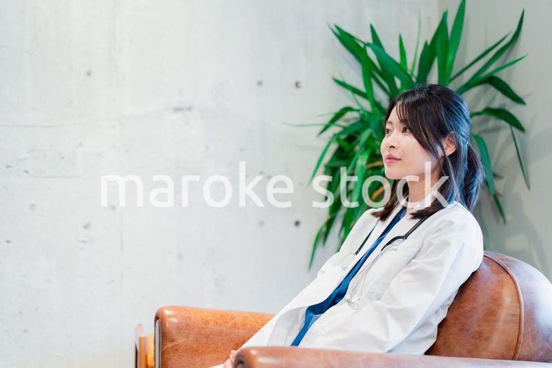 白衣で休憩をする女性の医師