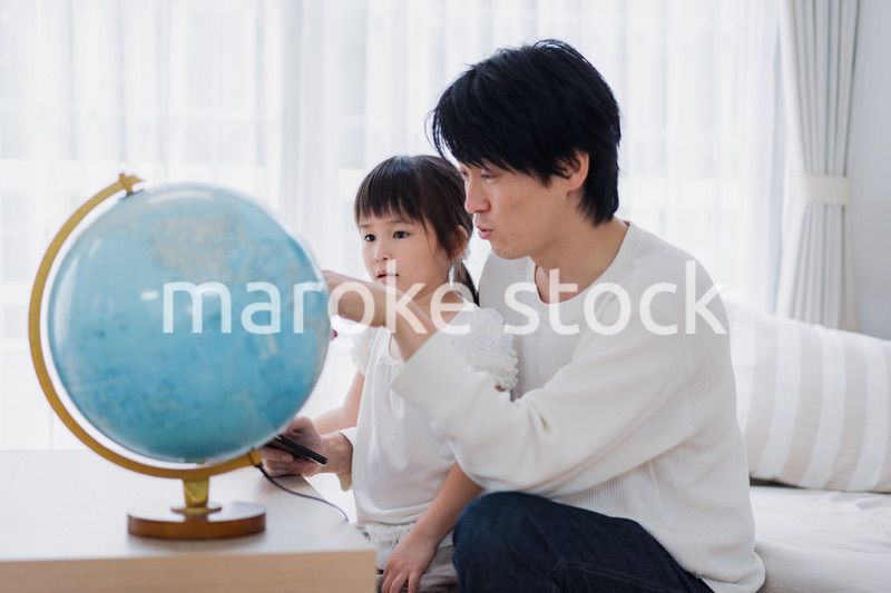 パパと地球儀を使って勉強する家族