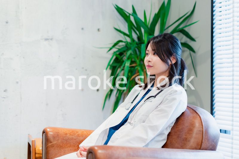 白衣で休憩をする女性の医師