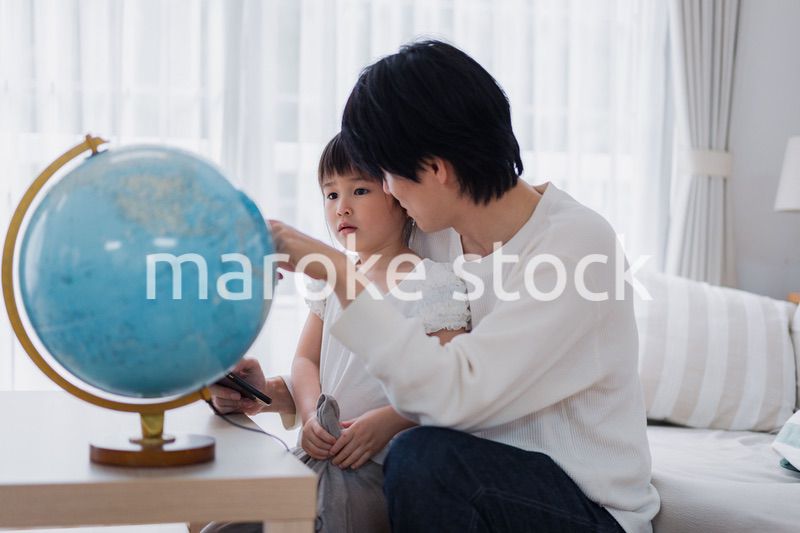 パパと地球儀を使って勉強する家族