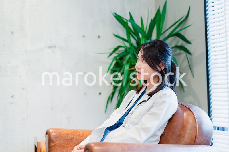 白衣で休憩をする女性の医師