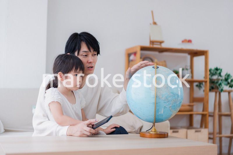パパと地球儀を使って勉強する家族