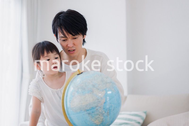 パパと地球儀を使って勉強する家族