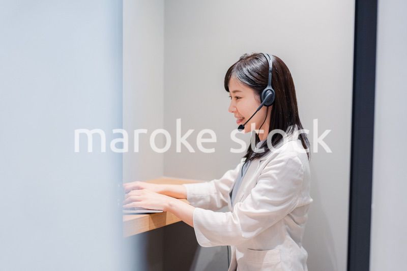 シェアオフィスの個室ブースでリモート会議をする女性