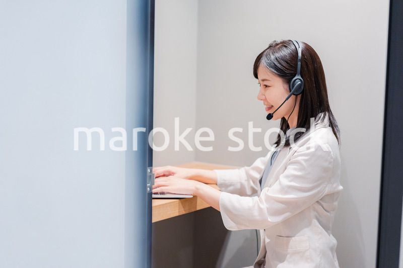 シェアオフィスの個室ブースでリモート会議をする女性