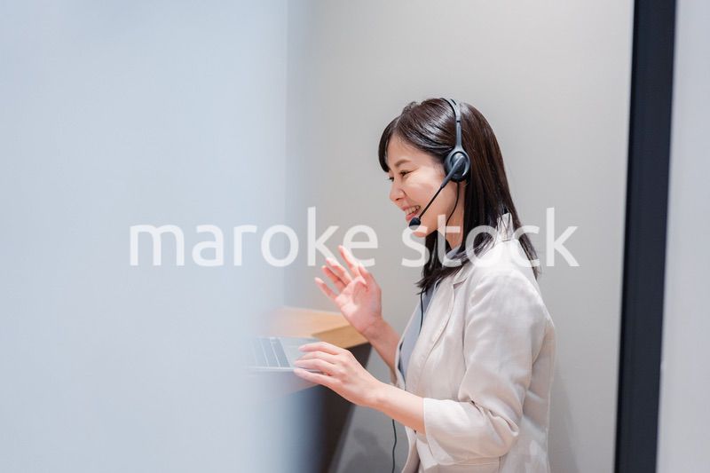 シェアオフィスの個室ブースでリモート会議をする女性