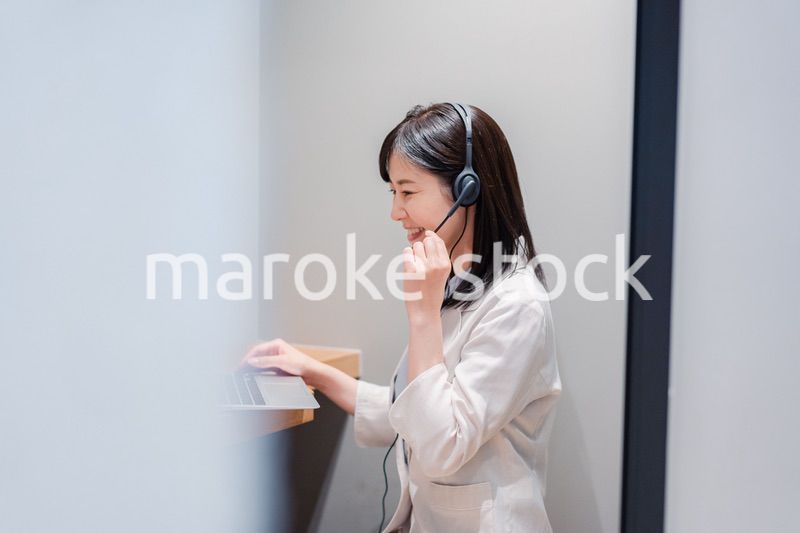 シェアオフィスの個室ブースでリモート会議をする女性