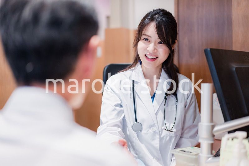 クリニックで男性患者の診察をする女性医師