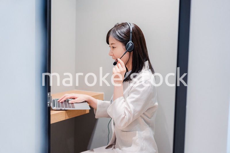 シェアオフィスの個室ブースでリモート会議をする女性