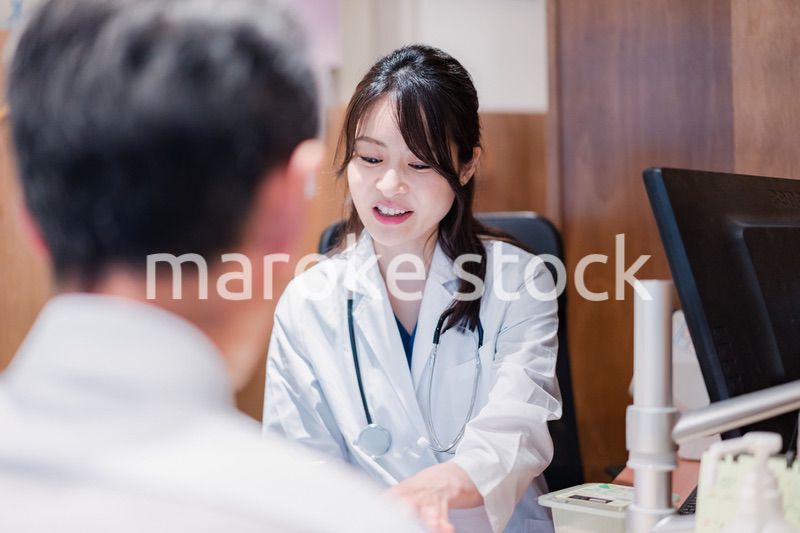 クリニックで男性患者の診察をする女性医師