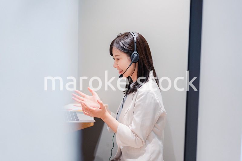 シェアオフィスの個室ブースでリモート会議をする女性