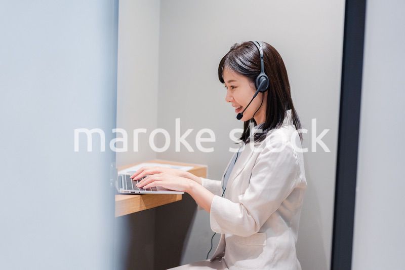 シェアオフィスの個室ブースでリモート会議をする女性