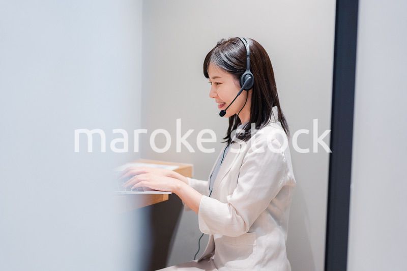 シェアオフィスの個室ブースでリモート会議をする女性