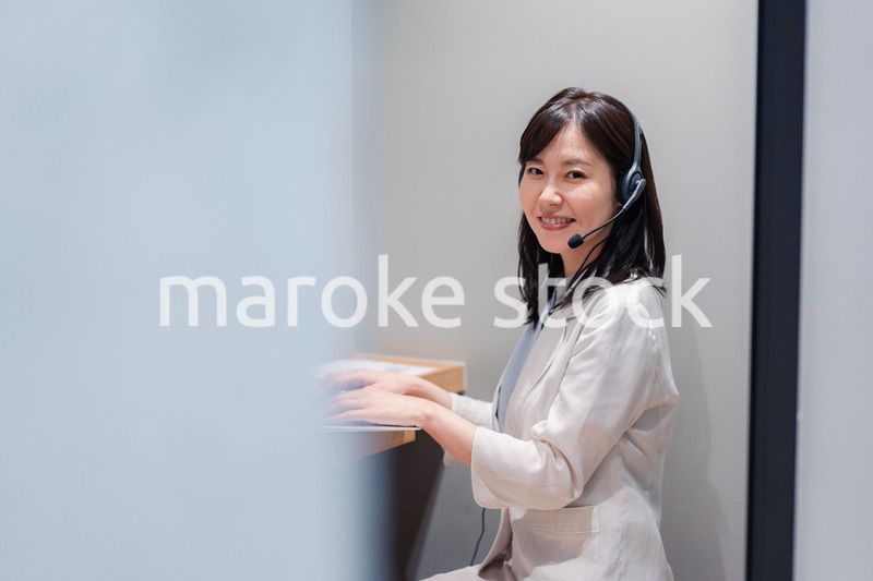 シェアオフィスの個室ブースでリモート会議をする女性