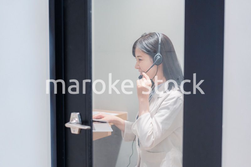 シェアオフィスの個室ブースでリモート会議をする女性