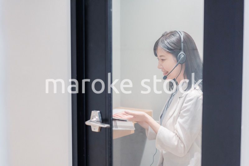 シェアオフィスの個室ブースでリモート会議をする女性