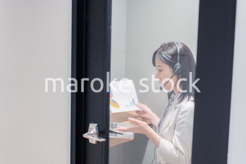 シェアオフィスの個室ブースでリモート会議をする女性