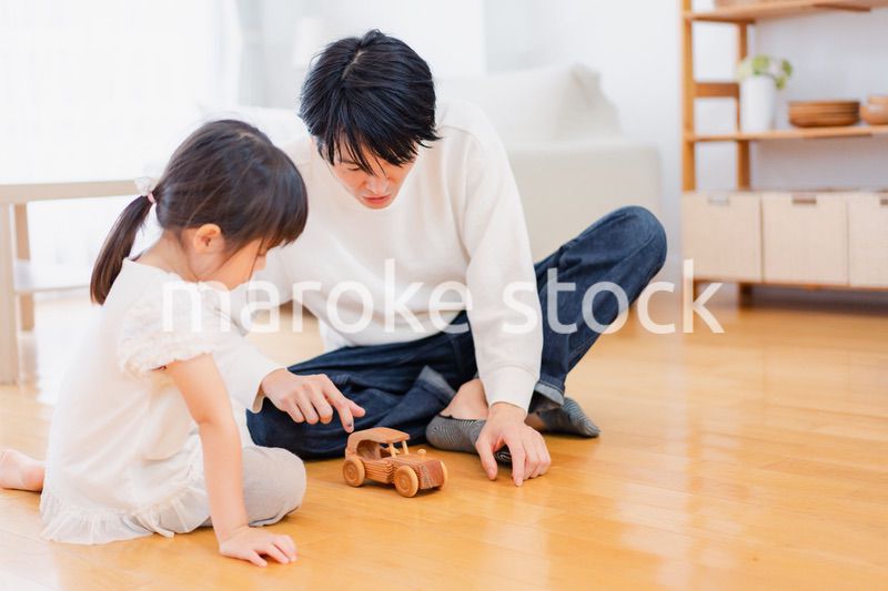 お父さんと一緒におうちで遊ぶ小さな女の子