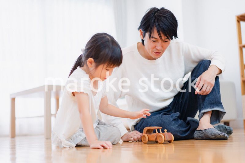 お父さんと一緒におうちで遊ぶ小さな女の子