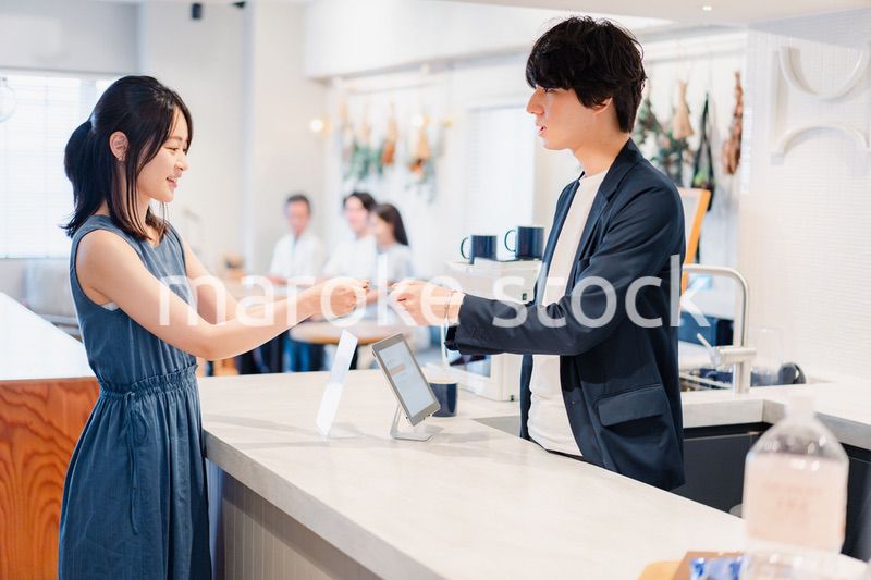 レジでクレジットカード決済をする若い女性