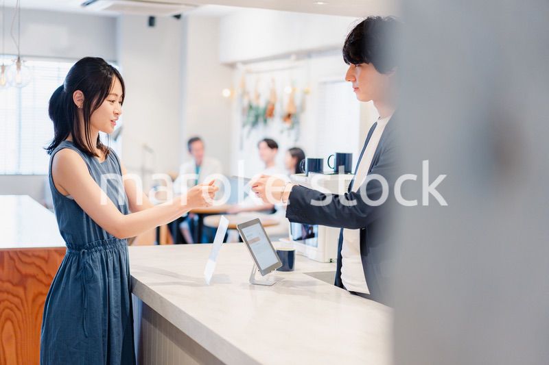 レジでクレジットカード決済をする若い女性