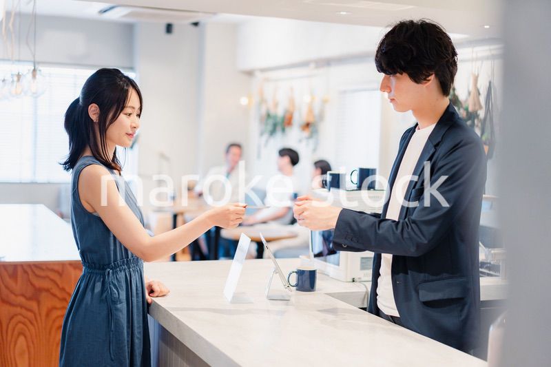 レジでクレジットカード決済をする若い女性