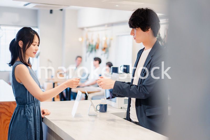 レジでクレジットカード決済をする若い女性