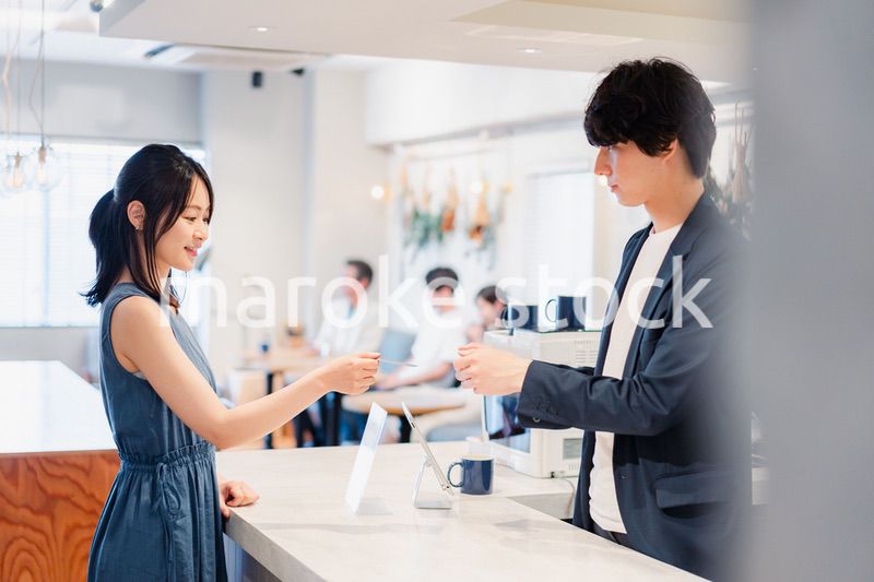 レジでクレジットカード決済をする若い女性