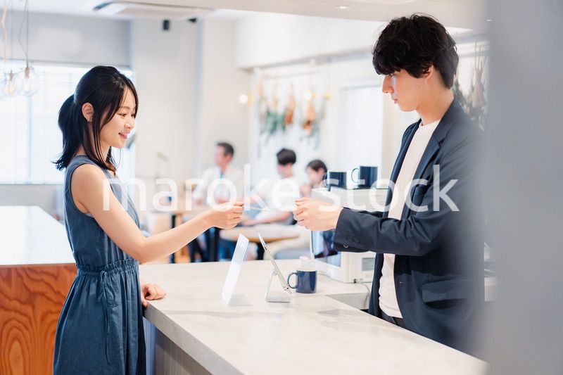 レジでクレジットカード決済をする若い女性