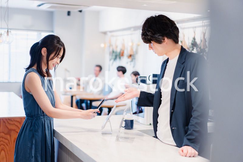 スマホ決済をする若い女性