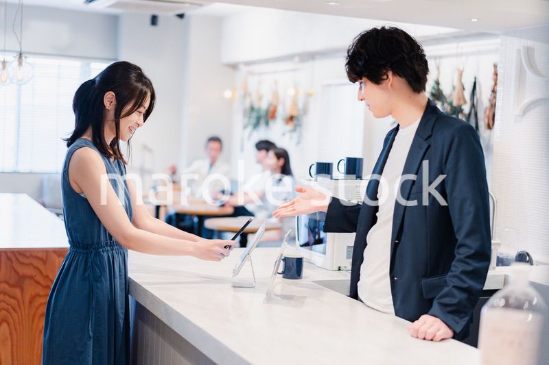 スマホ決済をする若い女性