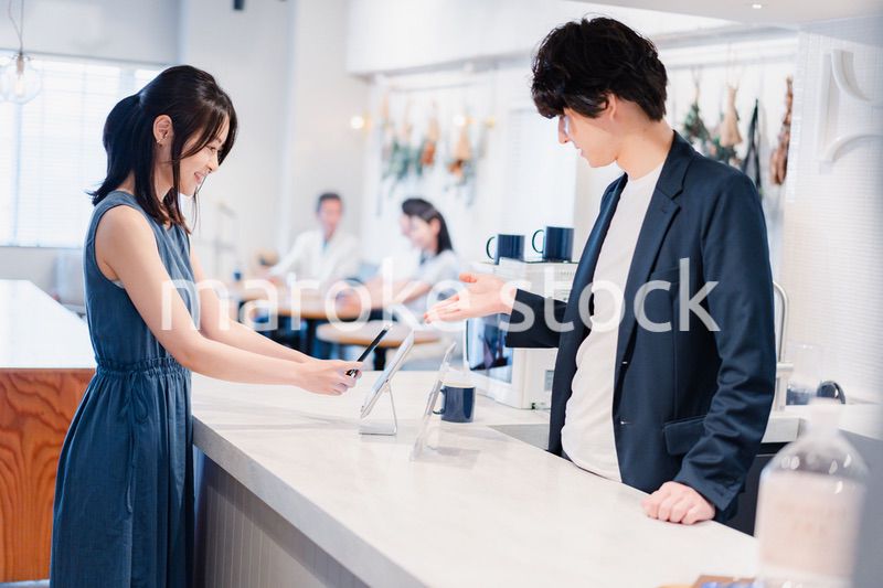 スマホ決済をする若い女性