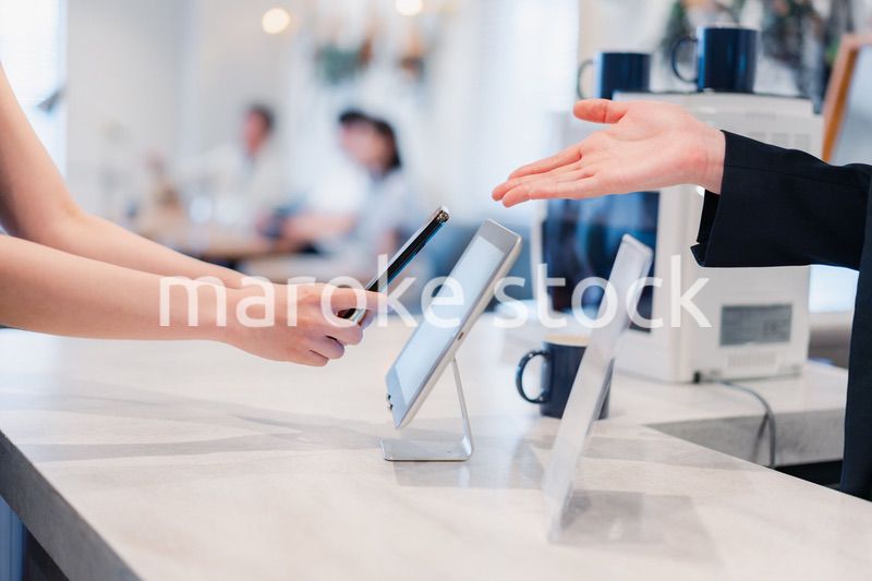 スマホ決済をする若い女性