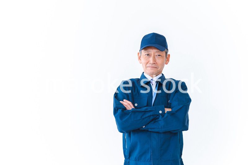 腕を組み笑顔を見せる配達員