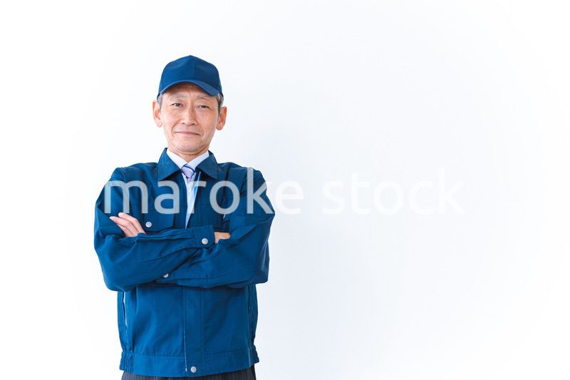 腕を組み笑顔を見せる配達員