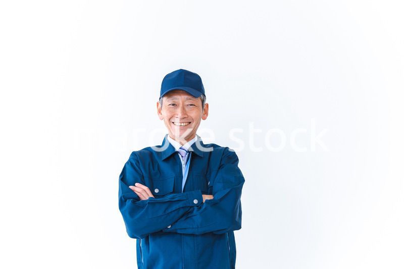 腕を組み笑顔を見せる配達員