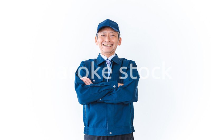 腕を組み笑顔を見せる配達員